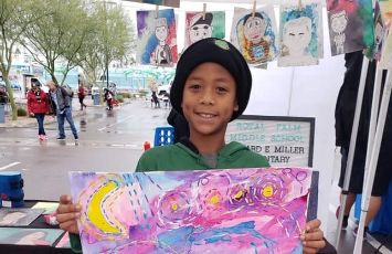  A student shows off a painting
